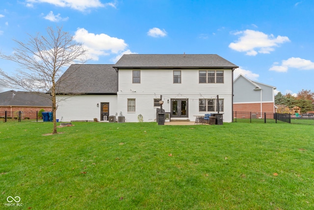 rear view of house featuring central air condition unit, french doors, and a yard