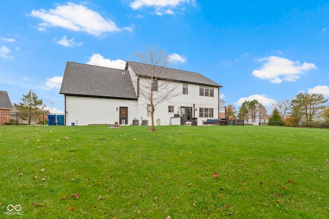 rear view of house featuring a lawn