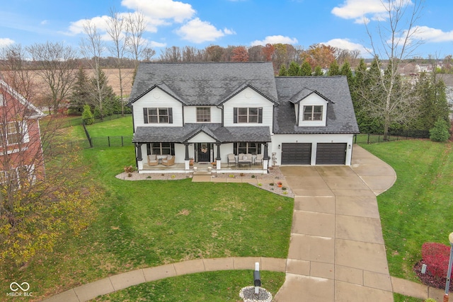 view of front of home with a front lawn, a garage, and a porch