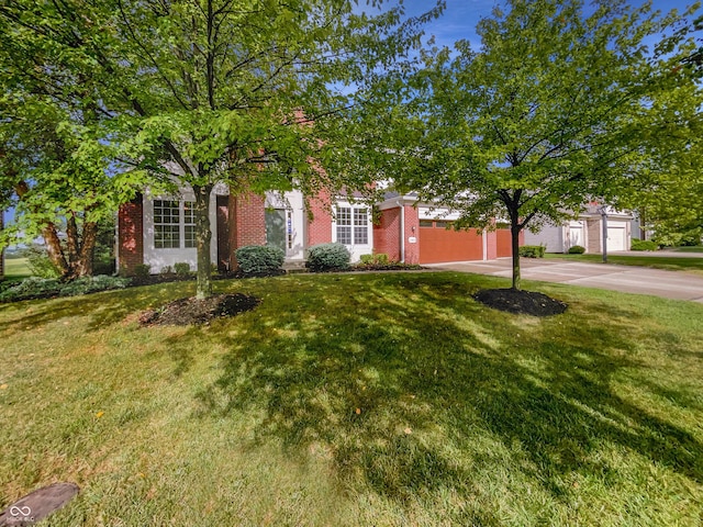 obstructed view of property featuring concrete driveway, brick siding, a front lawn, and an attached garage