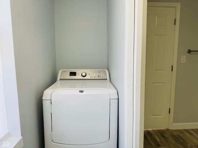 laundry area with dark wood-type flooring and washer / dryer