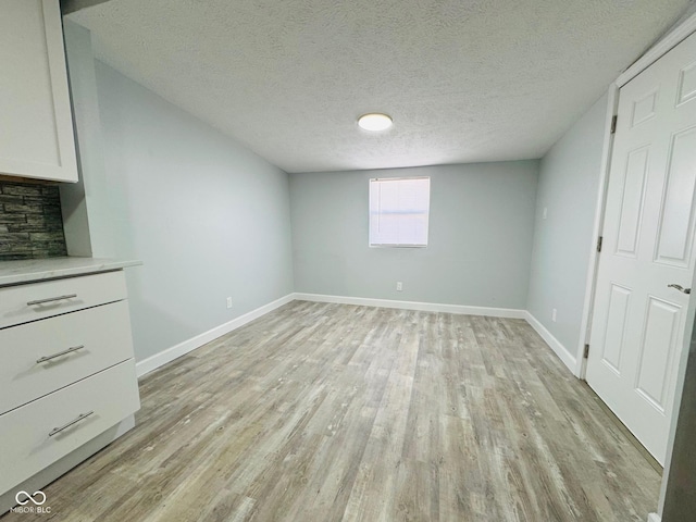 unfurnished bedroom featuring a textured ceiling and light hardwood / wood-style floors