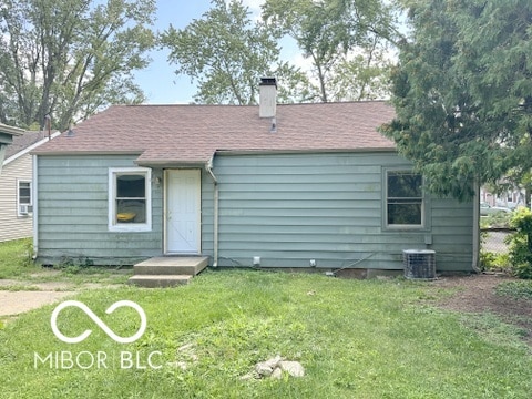 back of house featuring a lawn and central AC