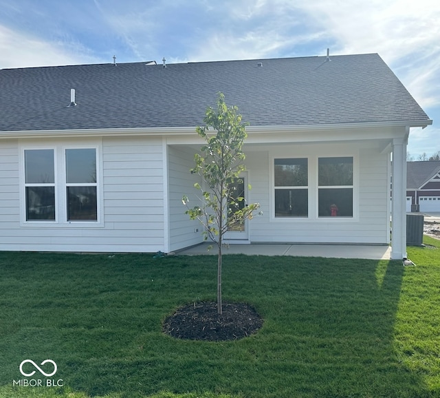 rear view of property featuring a yard, a patio, and central AC