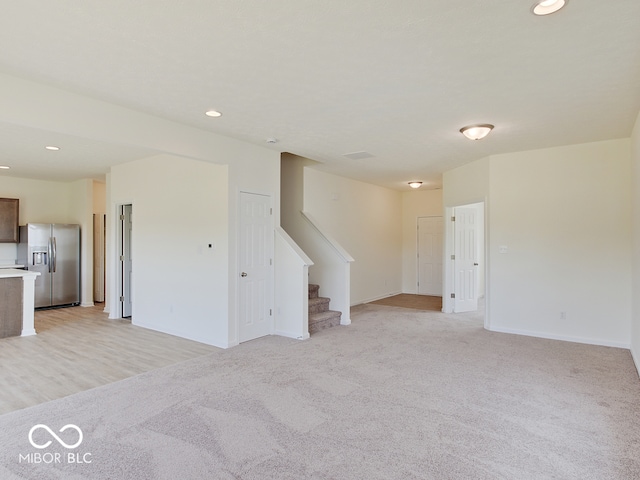 unfurnished living room featuring light colored carpet