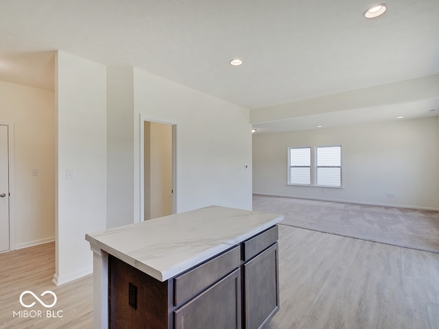 kitchen with light wood-type flooring, a center island, and dark brown cabinetry