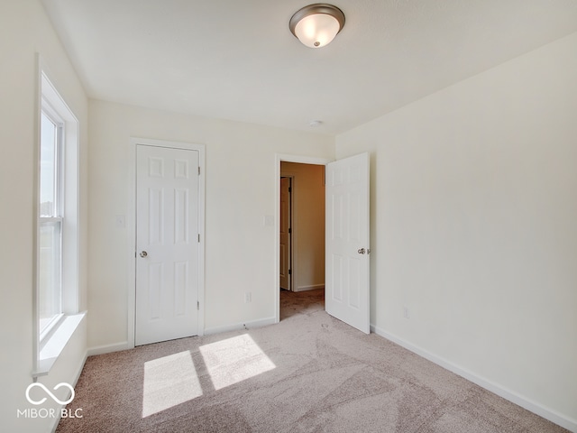 unfurnished bedroom featuring multiple windows and light carpet