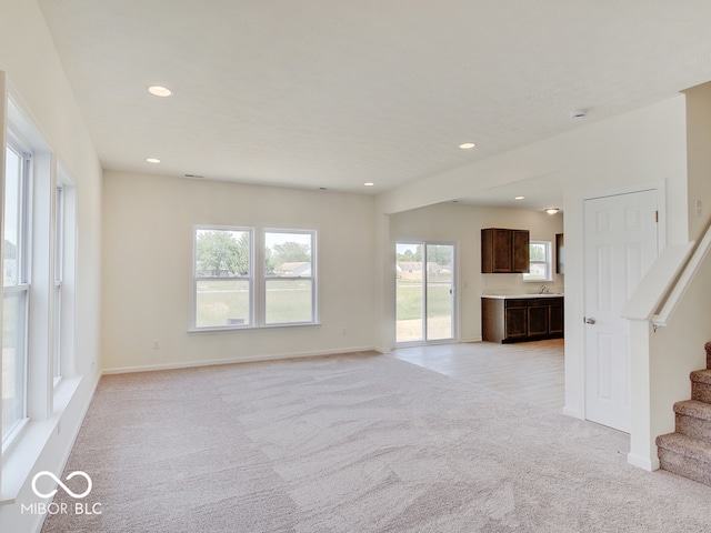 unfurnished living room with light colored carpet