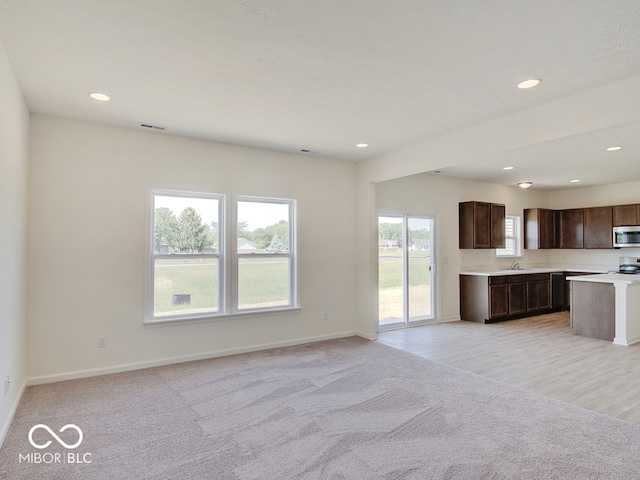 unfurnished living room with light colored carpet