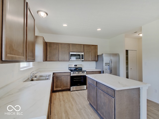 kitchen featuring a kitchen island, light hardwood / wood-style floors, sink, and appliances with stainless steel finishes