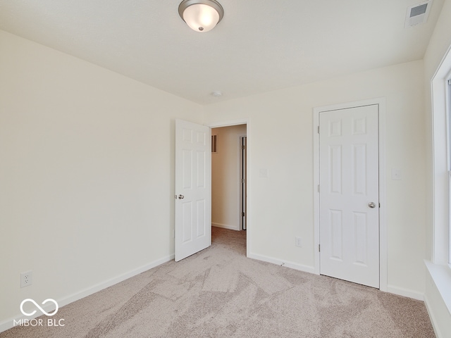 unfurnished bedroom with light carpet, visible vents, and baseboards