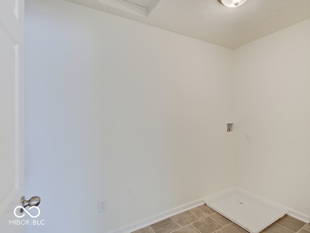 washroom with a textured ceiling, laundry area, hookup for a washing machine, and baseboards