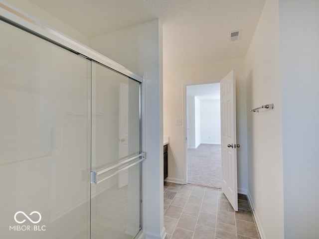 bathroom with visible vents, baseboards, vanity, and a shower stall