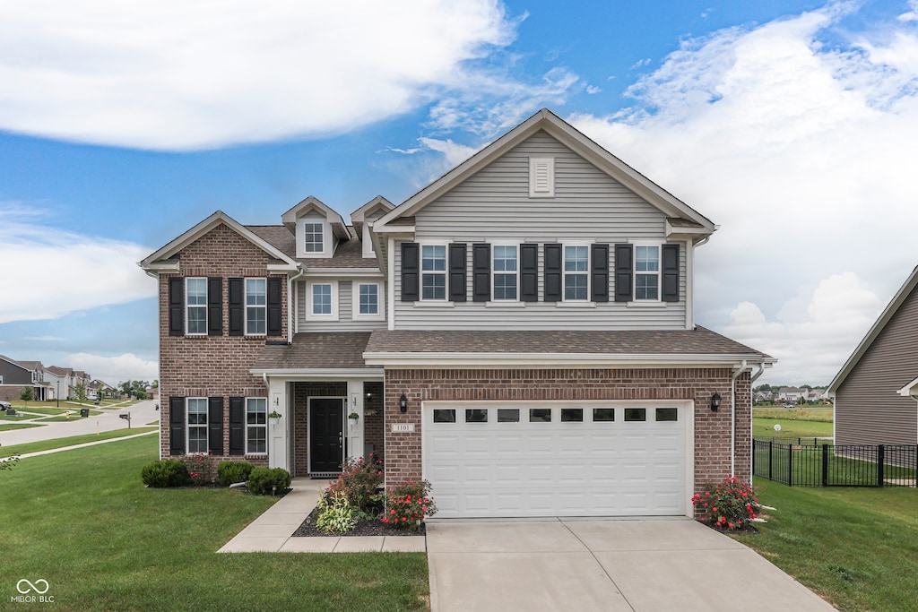 view of front of home with a garage and a front lawn