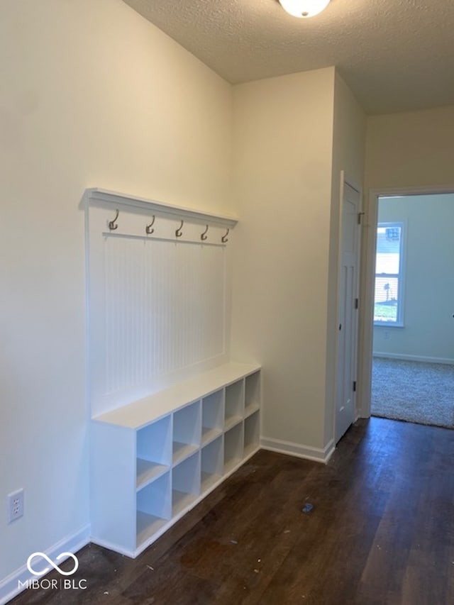 mudroom featuring a textured ceiling and dark hardwood / wood-style floors