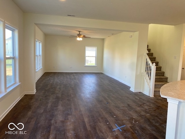 unfurnished living room with ceiling fan and dark hardwood / wood-style floors