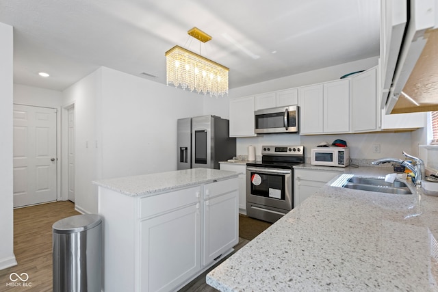 kitchen with a notable chandelier, white cabinetry, a center island, sink, and appliances with stainless steel finishes