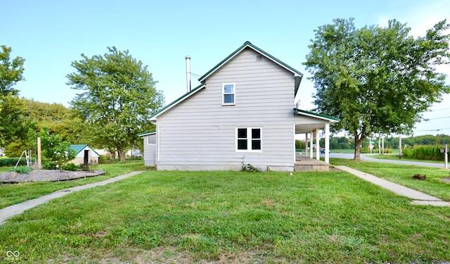 view of side of property with a yard and an outdoor structure