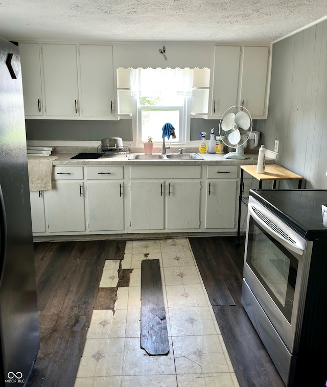 kitchen with white cabinets, appliances with stainless steel finishes, sink, and dark hardwood / wood-style flooring