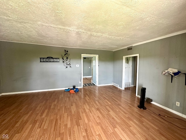 empty room featuring a textured ceiling and hardwood / wood-style floors