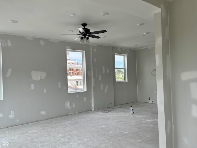 unfurnished room featuring ceiling fan and plenty of natural light