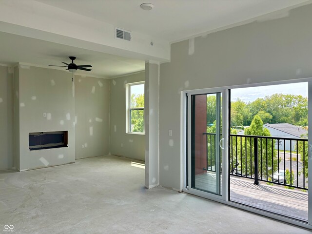 unfurnished living room with ceiling fan and concrete floors