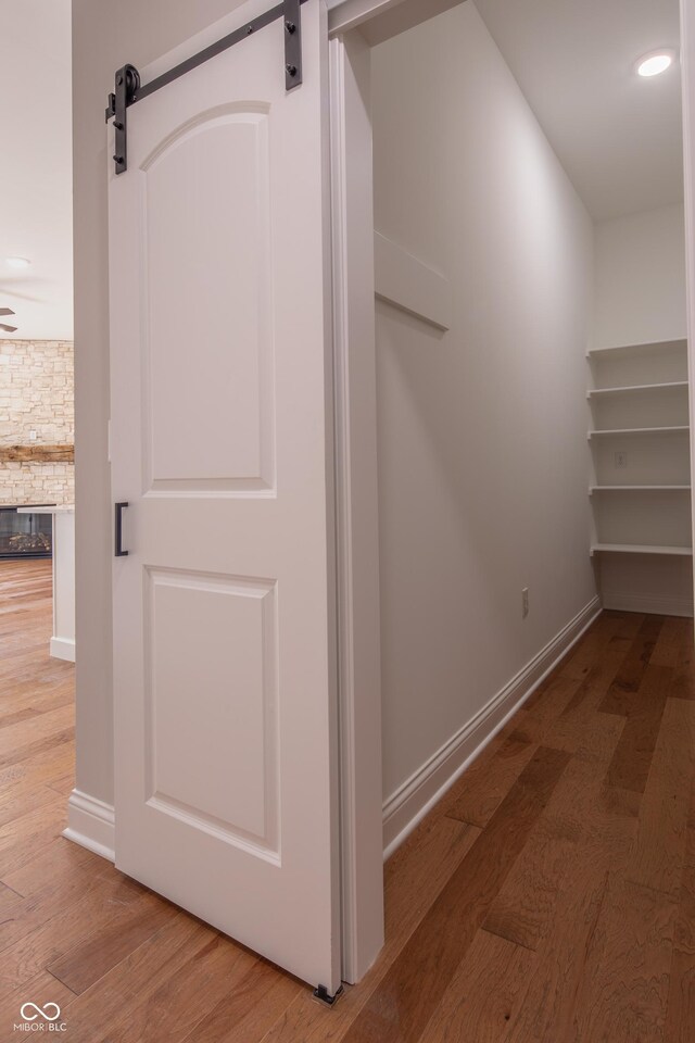 spacious closet with wood-type flooring and a barn door