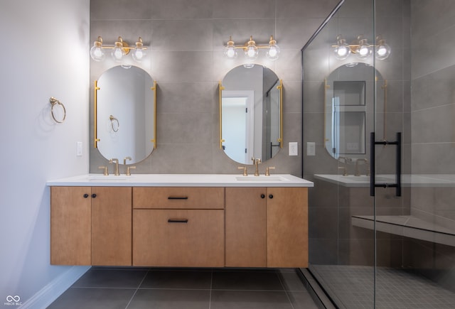 bathroom with an enclosed shower, double vanity, tile patterned flooring, and tile walls