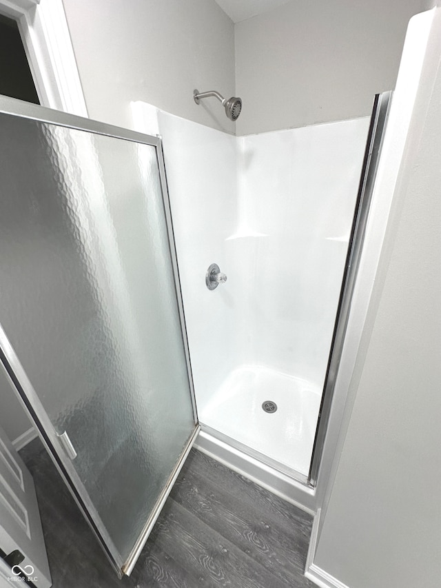 bathroom with hardwood / wood-style flooring and an enclosed shower