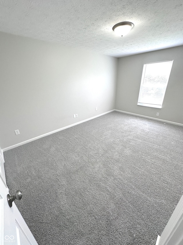 carpeted spare room with a textured ceiling