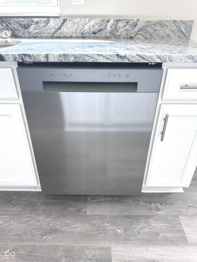 room details featuring dishwasher, white cabinets, and light stone counters