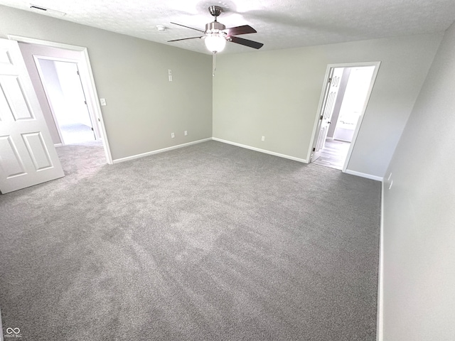 empty room featuring ceiling fan, a textured ceiling, and carpet flooring