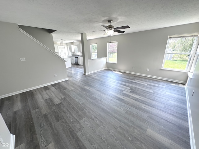 unfurnished living room with ceiling fan, hardwood / wood-style flooring, and a textured ceiling