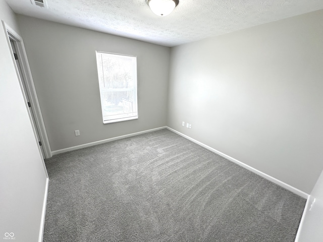 carpeted spare room featuring a textured ceiling