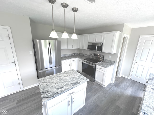 kitchen featuring pendant lighting, dark hardwood / wood-style flooring, white cabinetry, light stone counters, and stainless steel appliances