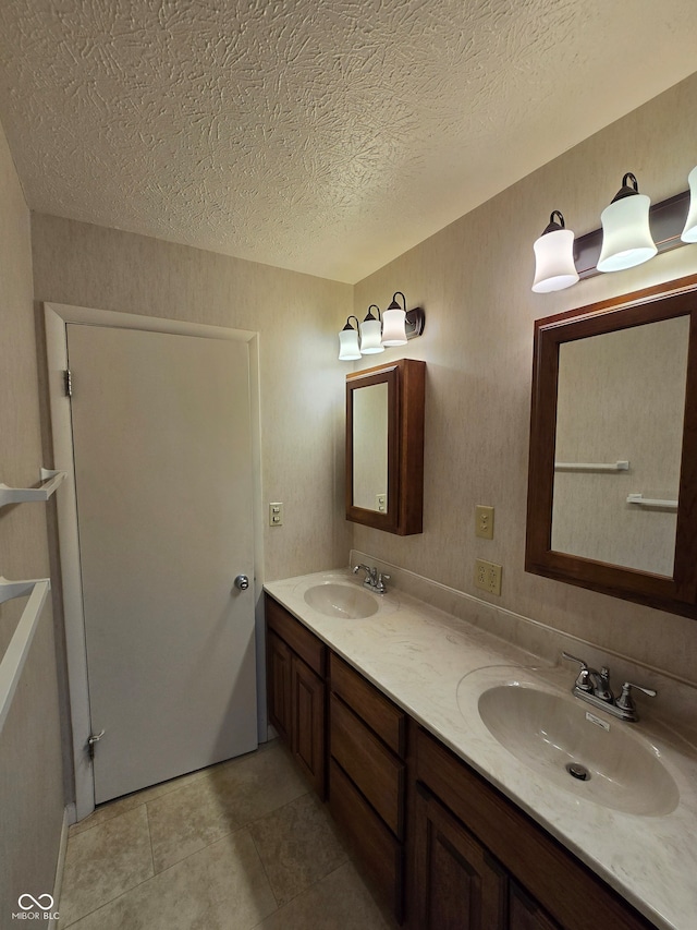 bathroom with a textured ceiling, vanity, and tile patterned floors