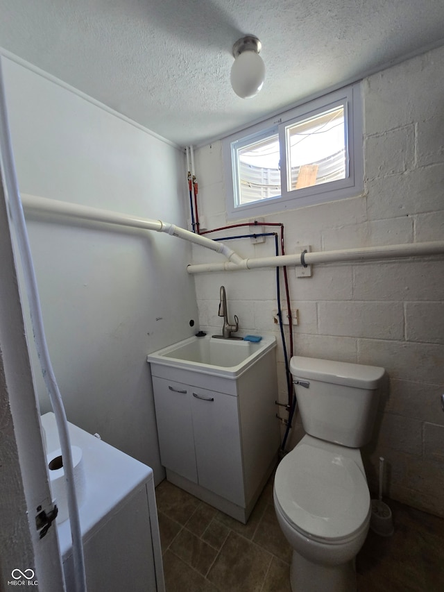 bathroom with tile patterned floors, a textured ceiling, vanity, and toilet