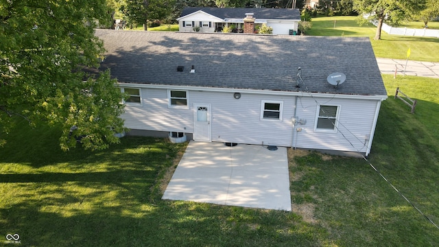 rear view of property featuring a patio and a yard