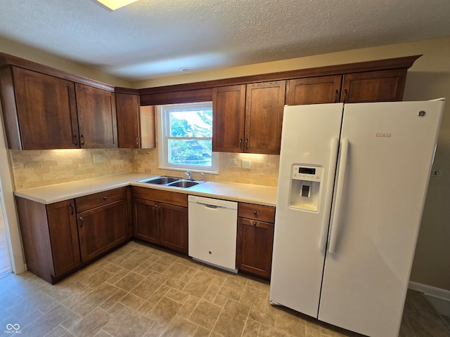 kitchen featuring light tile patterned flooring, sink, white appliances, tasteful backsplash, and a textured ceiling