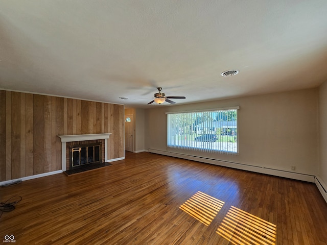 unfurnished living room with hardwood / wood-style floors, ceiling fan, and a fireplace