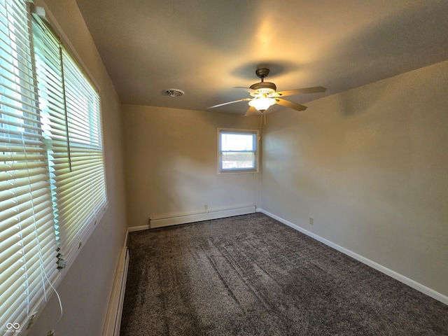 carpeted spare room featuring ceiling fan and a baseboard heating unit