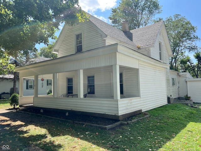 view of side of property with a yard and a porch