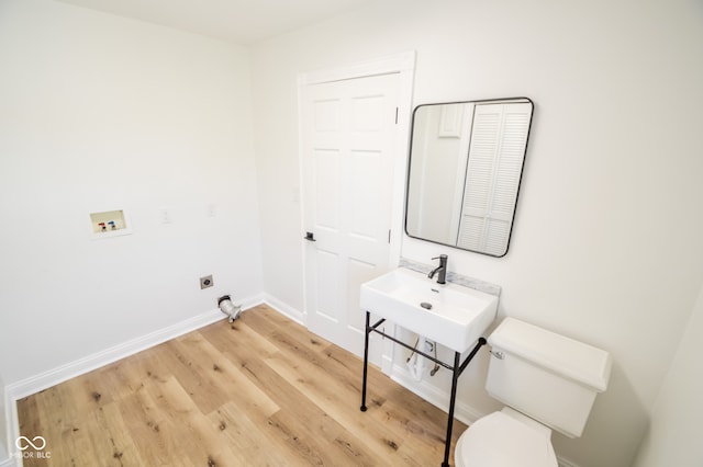 laundry room with sink, light hardwood / wood-style flooring, washer hookup, and electric dryer hookup