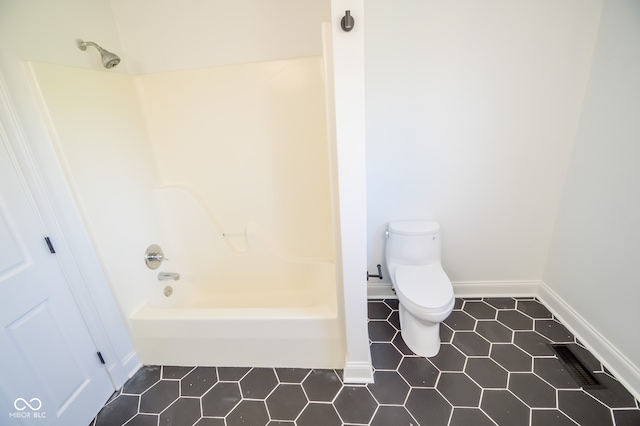 bathroom with bathing tub / shower combination, toilet, and tile patterned flooring