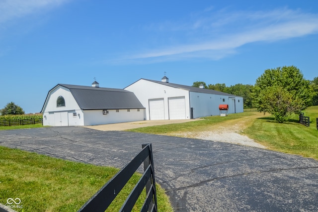 exterior space with a front lawn, an outdoor structure, and a garage