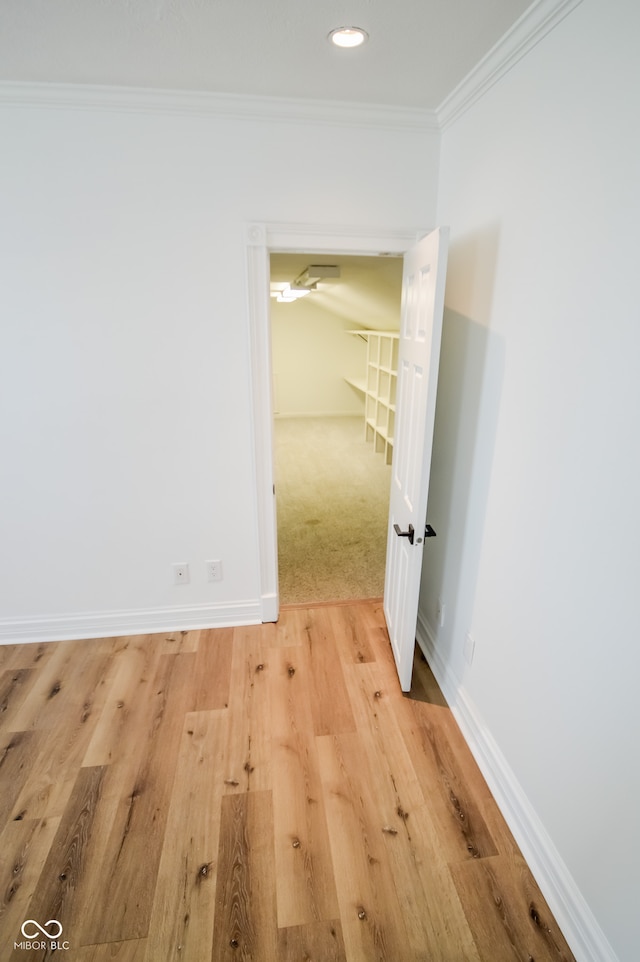 corridor featuring light hardwood / wood-style floors and crown molding