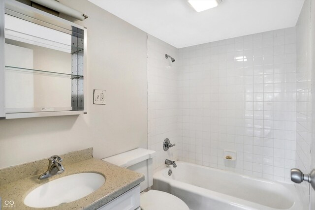 full bathroom featuring tiled shower / bath, toilet, and vanity