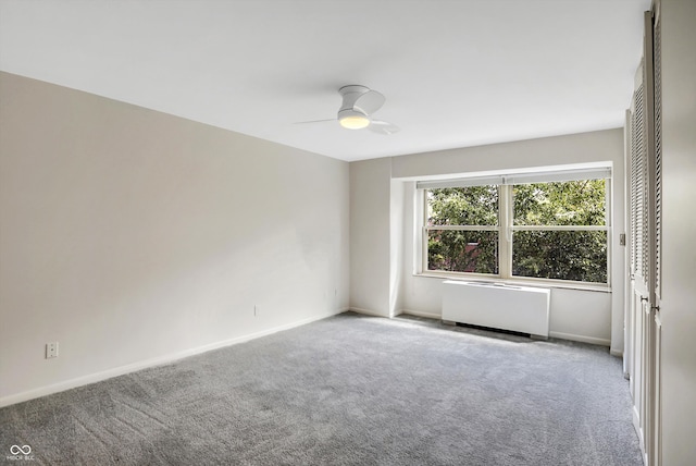 carpeted empty room featuring ceiling fan and radiator