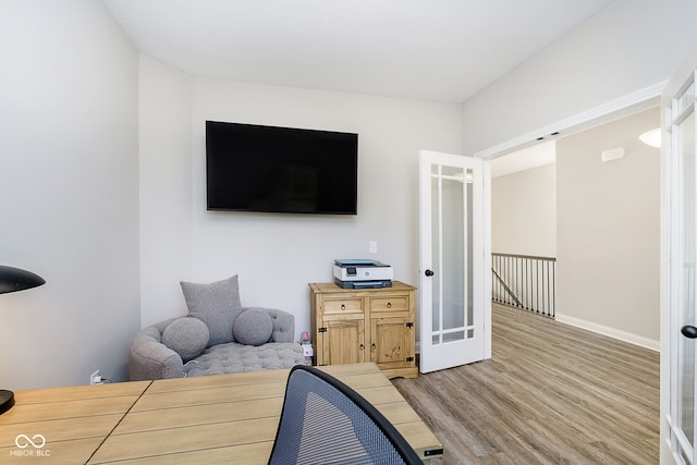 bedroom with french doors and light hardwood / wood-style floors