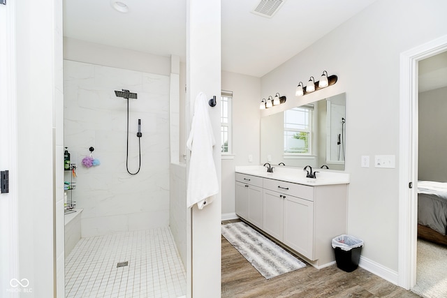 bathroom featuring tiled shower, vanity, and hardwood / wood-style floors